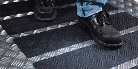 มีคนเดินบนเทปและดอกยางกันลื่น 3M Safety-Walk ที่ใช้กับพื้น

