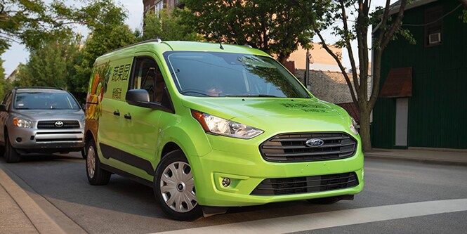 Green delivery van wrapped with a graphic film.
