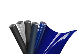 Five rolls of graphic film, with a shiny blue roll partly unfurled.