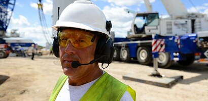 Worker wearing 3M Peltor protective communications on construction site
