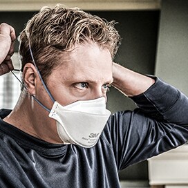 man putting on respirator
