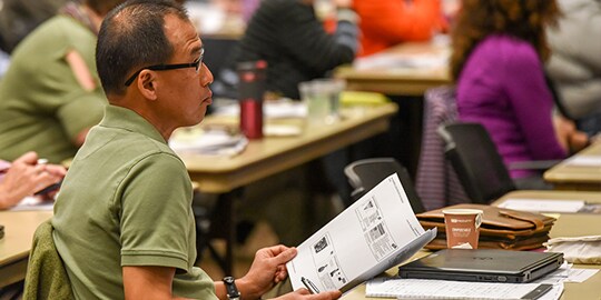 Hearing loss seminar attendee reviewing printed educational materials
