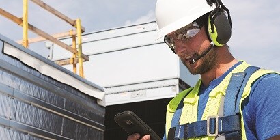 Worker wearing bluetooth-connected protective communications headset
