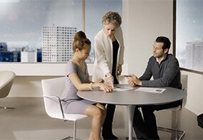 person standing next to a person holding a paper
