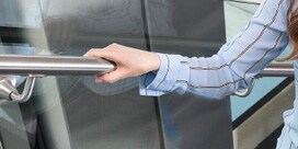 woman safely holding on to railing as she walks up a flight of stairs
