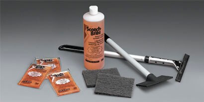 3M™ Scotch-Brite™ Quick Clean Griddle Cleaning System, including cleaning liquid, griddle pads, pad holder and squeegee.

