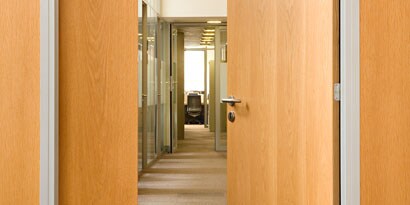 An office door and walls have 3M™ DI-NOC™ Architectural Finishes in wood grain.
