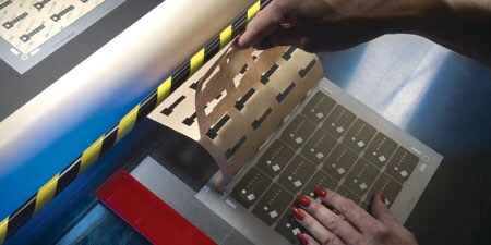 A person holding die-cut materials
