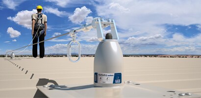 Worker on roof connected to permanently mounted anchor and cable system
