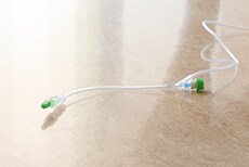 Disinfecting Port Protectors (green cap) on a needleless connector and male luer
