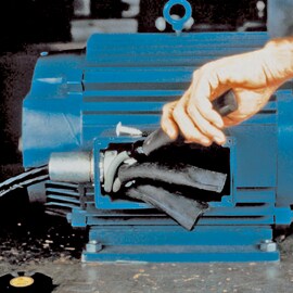 Open compartment of motor housing revealing electrical motor leads. Hand is pulling on rubber wrap around one lead