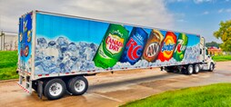 Semi-truck with images of soda cans on its fleet graphic wrap.