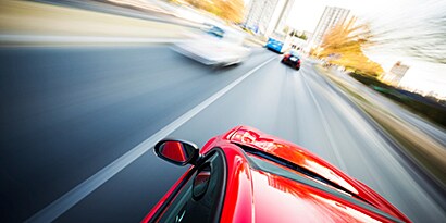 red car speeding down a freeway
