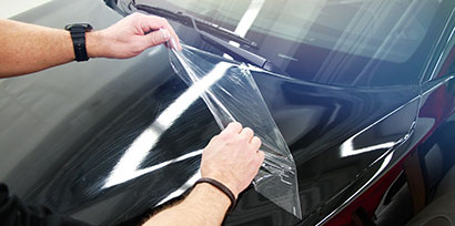 ตัวติดตั้งกราฟิกจะถอดชั้นฟิล์มป้องกันของ 3M™ Wrap Film Series 2080 ออกจากฝากระโปรงรถ
