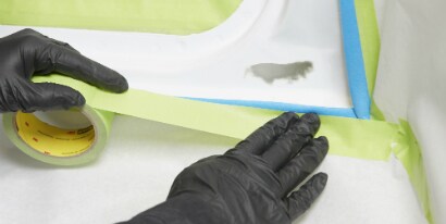 technician masking a car with 3M green tape
