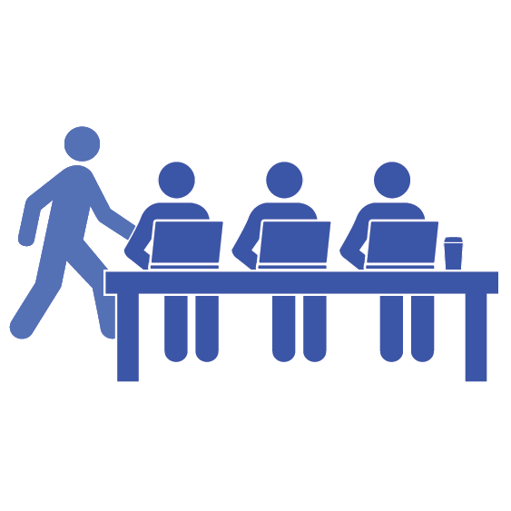 group of people sitting at a table with laptops