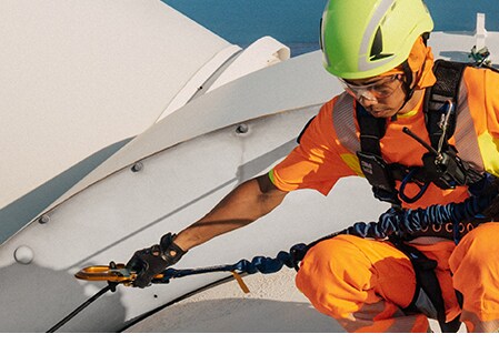 พนักงานสวมอุปกรณ์ป้องกันการตกขณะปฏิบัติงานบนยอดกังหันลม