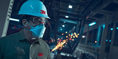  worker wearing 3M disposable respirator and hard hat
