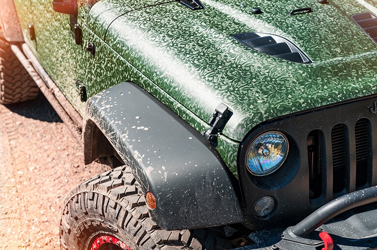 jeep driving through a field

