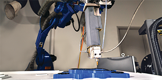 ภาพแขนหุ่นยนต์ติดเทป 3M™ VHB Extrudable กับชิ้นส่วนที่ซับซ้อนที่มีระดับความลึกแตกต่าง
