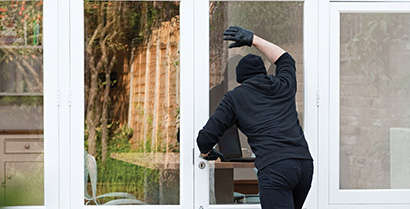 person in black mask and gloves opening a door
