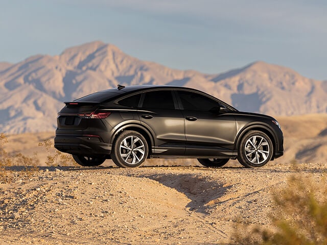 รถซีดานสีดำพร้อมฟิล์มใสกันรอยแบบด้าน จอดอยู่นอกถนน โดยมีภูเขาอยู่ด้านหลัง