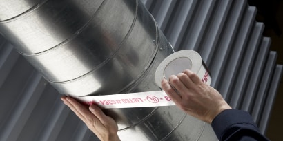 คนงานกำลังใช้ Scotch Foil Tape 3326 เทปฟอยล์ติดท่อ HVAC
