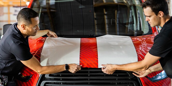 Two experts install a full color change and print wrap to a delivery vehicle.
