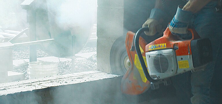 Worker sawing cement at a construction site.