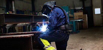 Metal production & fabrication: Man welding wearing PPE
