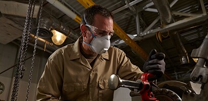 Metalworker wearing a 3M™ Respirator.
