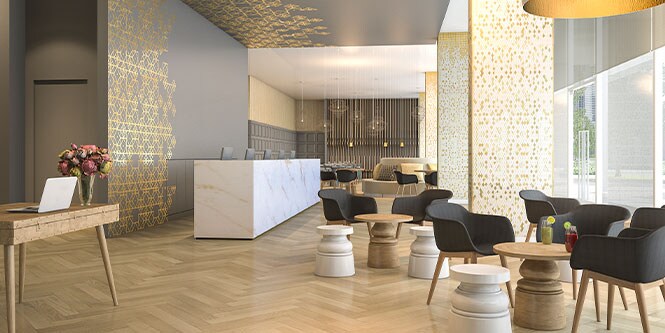 Immaculate interior design with lobby counter, lounge seats and tables and fancy wooden flooring.
