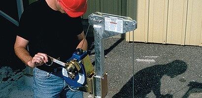 Worker operating winch ladder safety system
