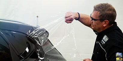 ตัวติดตั้งกราฟิกจะลบชั้นฟิล์มป้องกันของ 3M™ Wrap Film Series 2080 ออกจากด้านหลังของรถ
